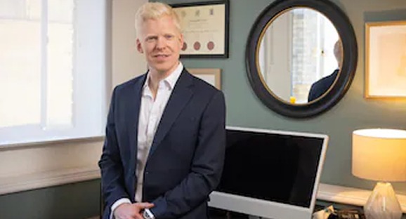 Photo of Dr Oscar Duke standing in his medical office.